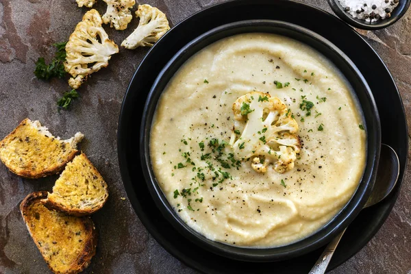 Zuppa di cavolfiore in ciotola nera rustica Vista dall'alto — Foto Stock