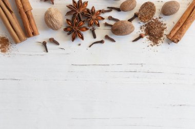 Baharat, tarçın, hindistan cevizi, yıldız anason ve desenli beyaz keresteye karanfil karışımı. Düz yatıyordu, üst görünüm, kopyalama alanı vardı. Noel tatili baharatları.