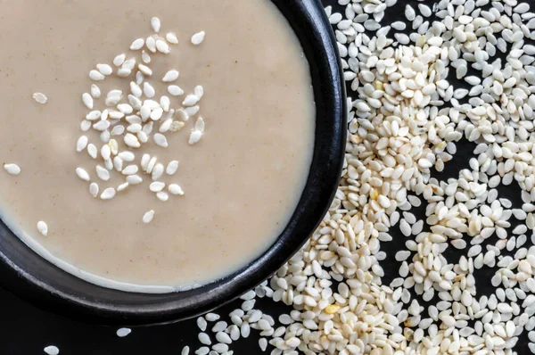 Tahini Schwarzer Schale Mit Sesam Ansicht Von Oben lizenzfreie Stockbilder