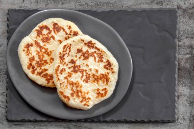 Kırsal gri tabakta ev yapımı düz ekmek. Üst Manzara. Lezzetli yoğurt pidesi..