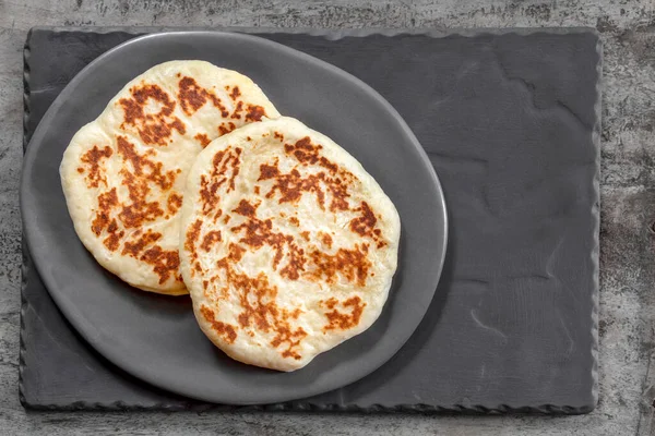 Kırsal gri tabakta ev yapımı düz ekmek. Üst Manzara. Lezzetli yoğurt pidesi..