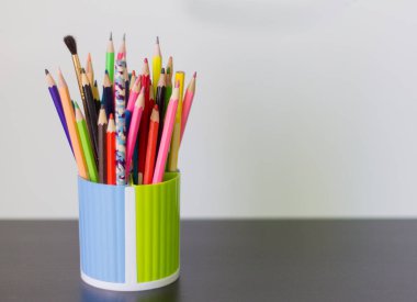 renkli kalemler ve Kalem masanın üzerine bir bardak