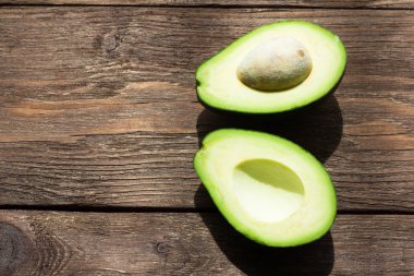 yeşil avokado üzerine sığ bir alan derinliği ile ahşap bir masa yarım kesilmiş