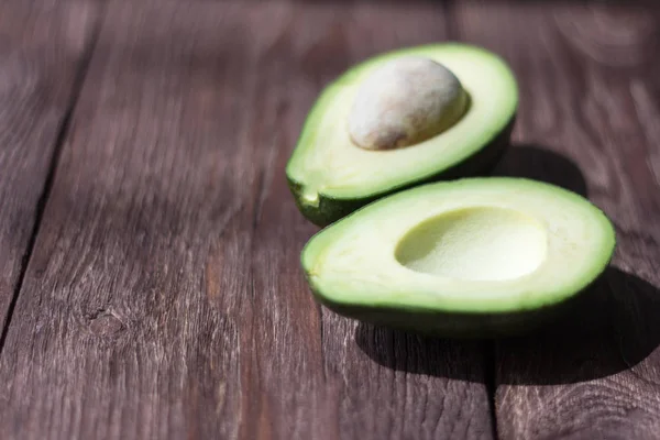 Grüne Avocado Halbiert Auf Einem Holztisch Mit Geringer Schärfentiefe — Stockfoto