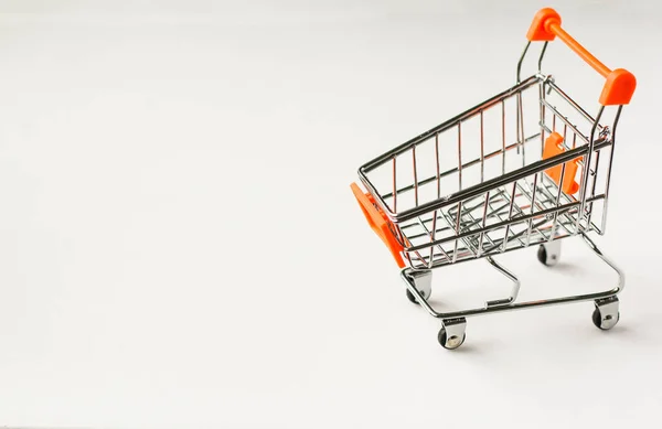 空のスーパー マーケットの白い背景の上ショッピングカート — ストック写真