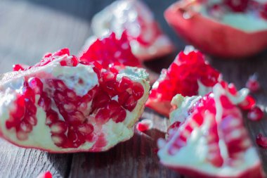 Kırmızı nar, nar dilimleri ahşap arka plan üzerinde