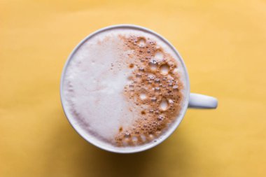  Kapuçino sarı arka planda, üstten görünüm kahve fincan