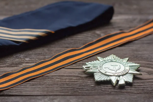 The symbols of victory,St. George ribbon,order and a soldier's cap on a wooden background