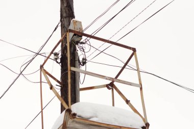 old wooden pole with electric and telephone wires