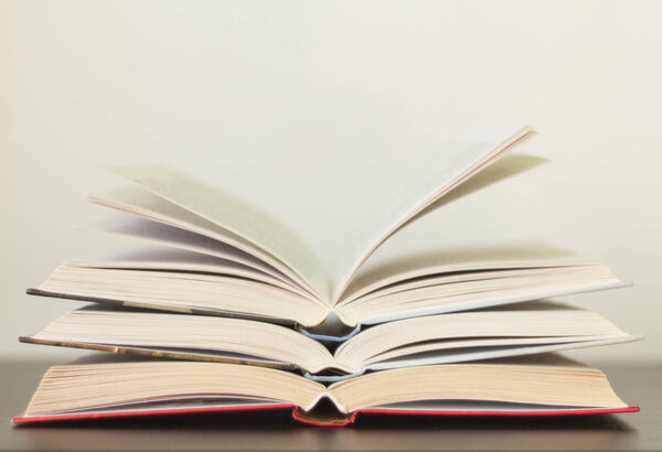 несколько открытых книг на столе
