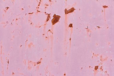 Paslı, pembe duvarlı, boyasından düşmüş, paslı bir arka planı var.