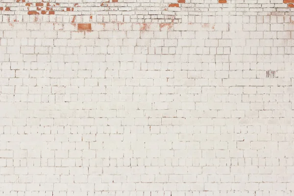 brick background, old brick wall painted white and with fallen off plaster