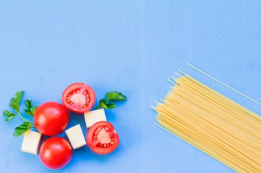 Spagetti ve pişirme malzemelerin üzerine mavi ahşap arka plan