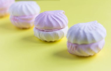 lezzetli bir tatlı, sarı bir arka plan üzerinde hassas bir beyaz ve pembe marshmallow