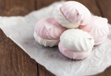 lezzetli tatlı, ahşap arka plan üzerinde beyaz kağıt üzerinde hassas beyaz ve pembe marshmallow