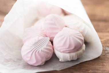 lezzetli tatlı, narin beyaz ve pembe marshmallow ahşap arka plan üzerinde beyaz kağıt