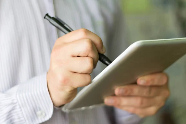 Elinde dijital tablet tutan genç adam, yakın plan.