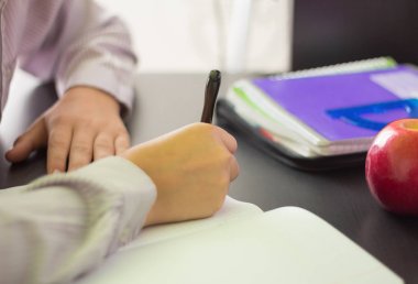 bir lise öğrencisi veya bir öğrenci, ödev yapıyor, bir Masa bir not defterine yazıyor