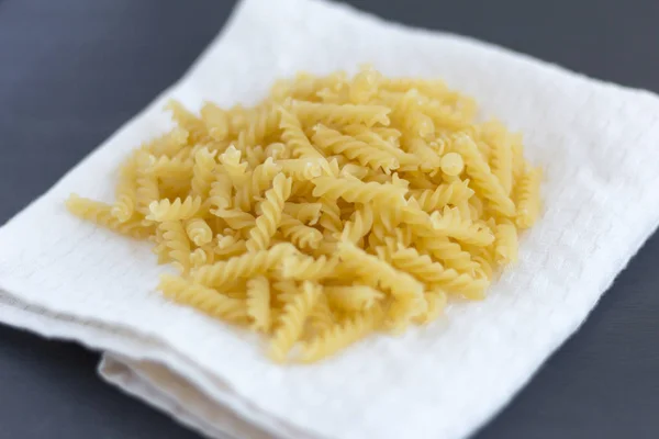 Włoski Fusilli, spirale, makaron na ciemnym tle, Kopiuj przestrzeń — Zdjęcie stockowe