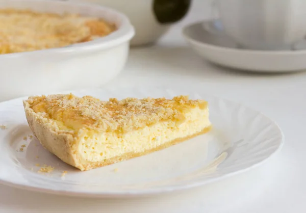 delicious fresh cottage cheese pie with shortbread and tea utensils on the table