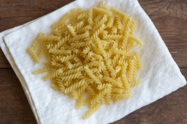 Pasta fusilli para cocinar, primer plano sobre la mesa —  Fotos de Stock