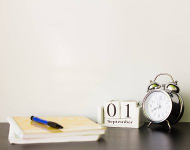 1 Eylül tahta bir takvim üzerinde çalar saat yanında, öğretim yılı başında kavramı