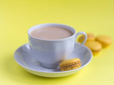 makaronlar, lezzetli badem kurabiye ve masada krema ile kahve fincanı