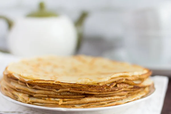 Leckere frische hausgemachte Pfannkuchen und Utensilien für Tee auf dem Tisch — Stockfoto