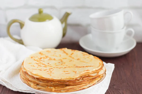Leckere frische hausgemachte Pfannkuchen und Utensilien für Tee auf dem Tisch — Stockfoto