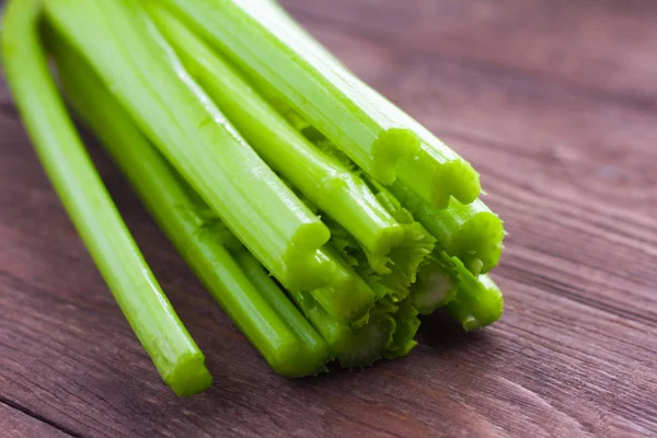 Primo piano di sedano su sfondo di legno. Gambi di sedano verde biologico fresco primo piano. Note di alimentazione, concetto di dieta — Foto Stock