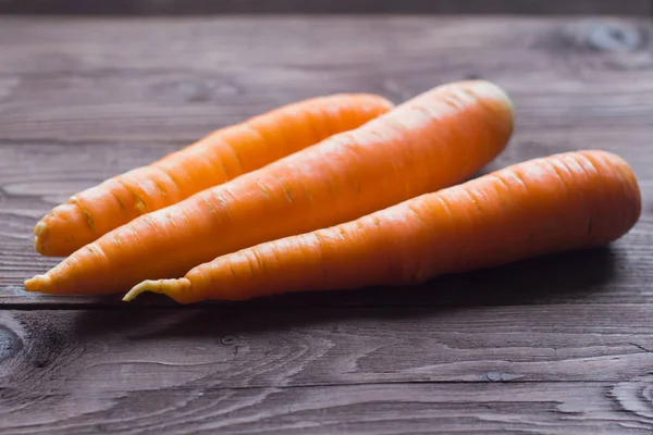 Zanahorias frescas maduras sobre fondo de madera, vista superior — Foto de Stock