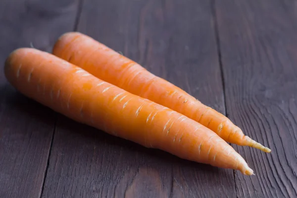 Zanahorias frescas maduras sobre fondo de madera, vista superior — Foto de Stock
