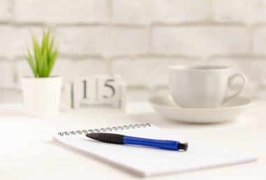 pencerenin yanında masada bir kalem ve bir kahve Fincanı ile temiz bir defter