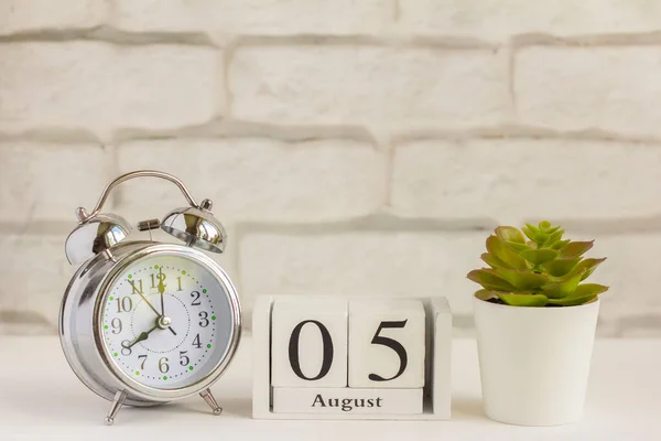 5 Agustus pada kalender kayu di sebelah jam alarm. Hari musim panas, ruang kosong untuk teks .Calendar untuk Agustus pada latar belakang cahaya. — Stok Foto