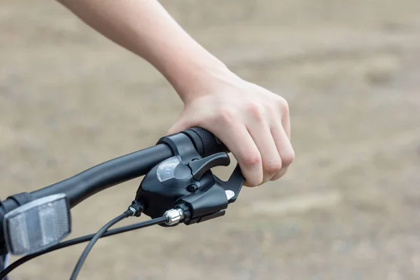 Close-up of a teenager\'s hands on the handlebars of a Bicycle.