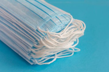 Virüslere karşı korunmak için antiviral tıbbi maskeler. Cerrahi koruyucu maske. Mavi arka planda bir sürü yeni tıbbi maske..