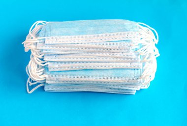 Virüslere karşı korunmak için antiviral tıbbi maskeler. Cerrahi koruyucu maske. Mavi arka planda bir sürü yeni tıbbi maske..