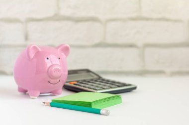 Piggy Bank, hesap makinesi ve notlar için not defteri. Bütçe muhasebesini tutma kavramı.