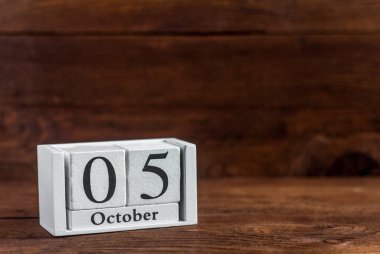 Takvimde 5 Ekim. Koyu ahşap bir arka plan. Sonbahar ayının tarihi..