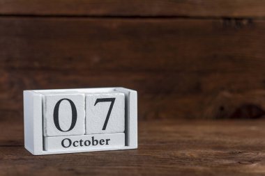 Takvimde 7 Ekim. Koyu ahşap bir arka plan. Sonbahar ayının tarihi..
