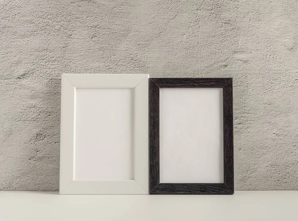 Due cornici fotografiche vuote su un tavolo o uno scaffale con una copia dello spazio — Foto Stock
