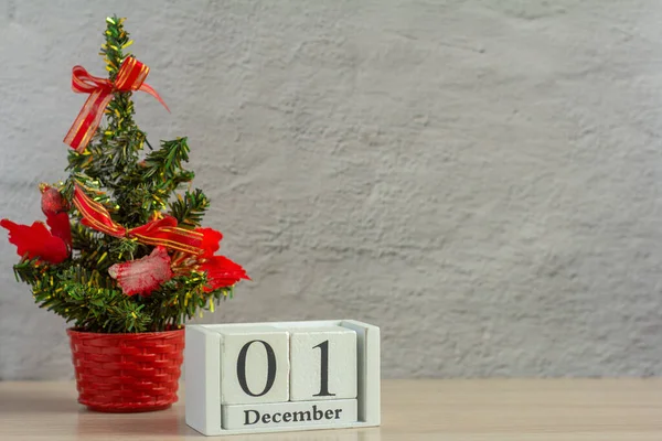 1 Aralık ayın ilk günü, gri arka planda küçük bir Noel ağacı olan takvim. Merhaba kış. Yeni yıl kavramı.