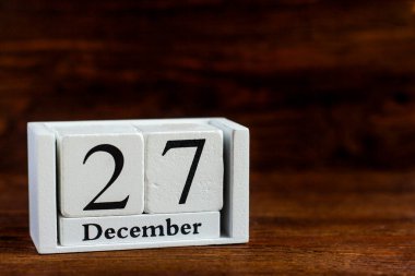 Takvimde 27 Aralık. Koyu ahşap arka plan. Kış ayının tarihi.