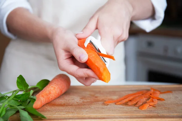 Manos Una Mujer Joven Delantal Fondo Cocina Pelando Verduras Zanahoria — Foto de Stock