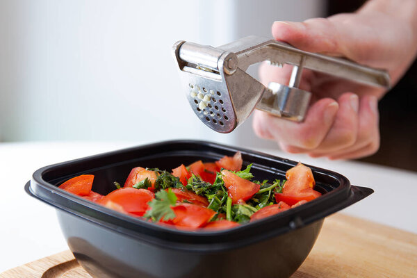 Соус сальсы. Сочные красные нарезанные помидоры с травами, лимоном и чесноком. Домашняя кухня. Свежие ингредиенты или овощи для соуса сальсы. Мужские руки держат чесночный пресс или чеснок сжиматель
.