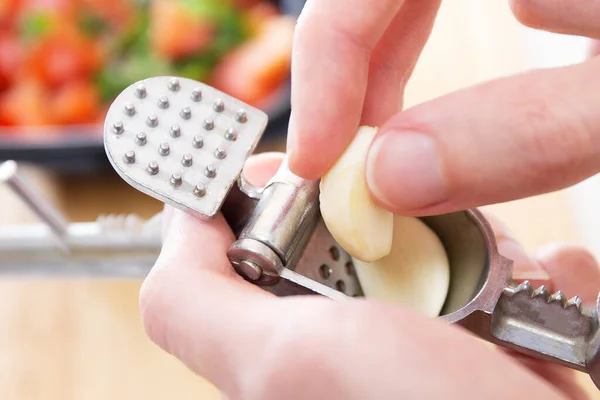 Salsa Dip. Meyveli, kırmızı domatesli, otlu, limonlu ve sarımsaklı. Ev yapımı yemek. Salsa sosu için taze malzeme ya da sebze. Erkek eller sarımsak eziciye ya da meyve sıkacağının içine sarımsak karanfilleri koyar..