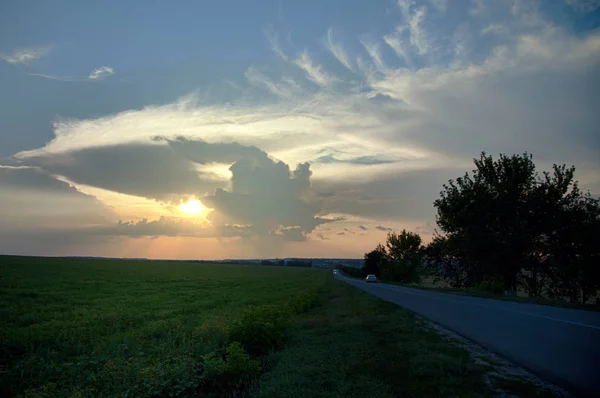 Σύννεφα Στο Ηλιοβασίλεμα Πάνω Από Πράσινο Πεδίο Δρόμο — Φωτογραφία Αρχείου