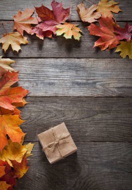 ahşap arka plan üzerinde sonbahar yaprakları ile karton kutu