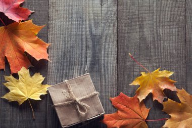 ahşap arka plan üzerinde sonbahar yaprakları ile karton kutu