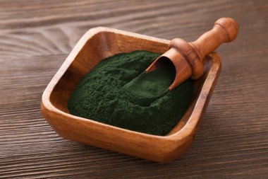 Ahşap kutusunda yeşil spirulina tozu